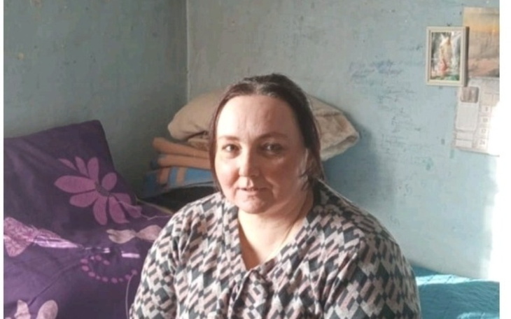 Kobieta siedząca w pokoju z niebieskimi ścianami.