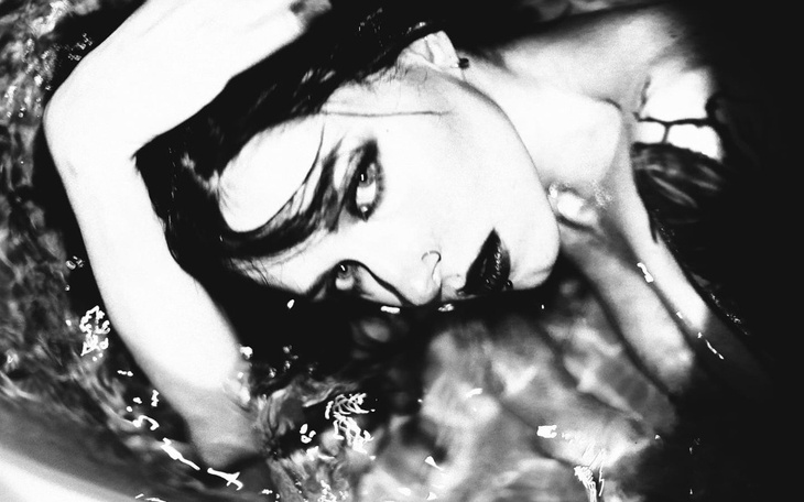 Artystyczne czarno-białe zdjęcie kobiety w wodzie.