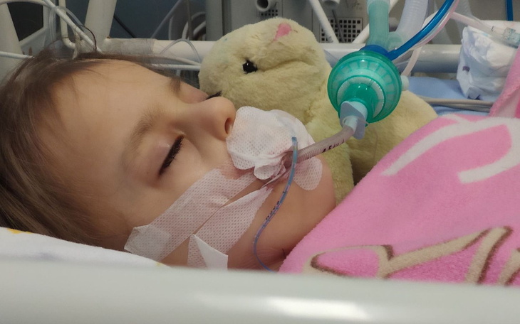 Dziecko w szpitalu z maską tlenową i pluszowym misiem.