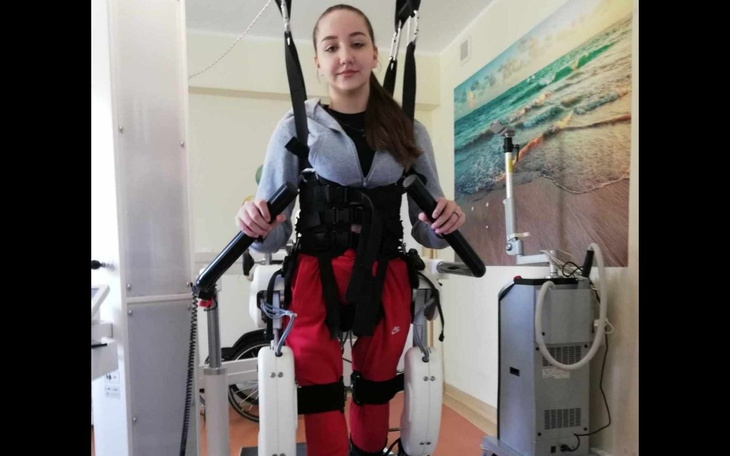 Młoda dziewczyna w egzoszkielecie, ćwiczy rehabilitację.