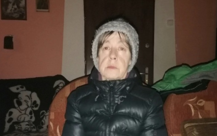 Kobieta w ciepłej czapce, siedząca w domu.