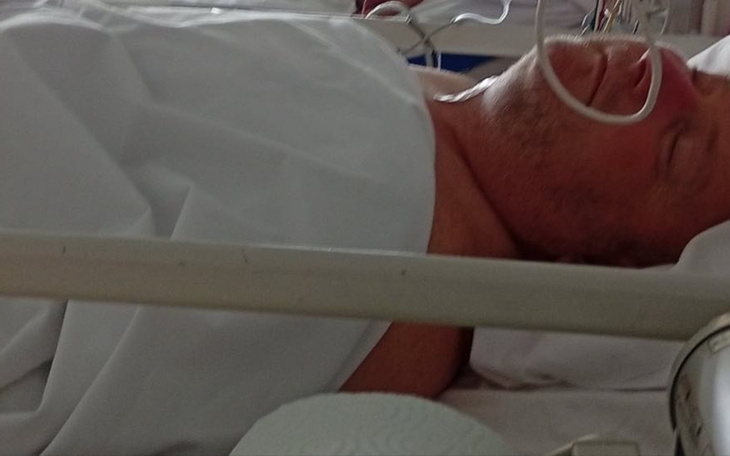 Mężczyzna leżący w szpitalnym łóżku, podłączony do aparatury medycznej.