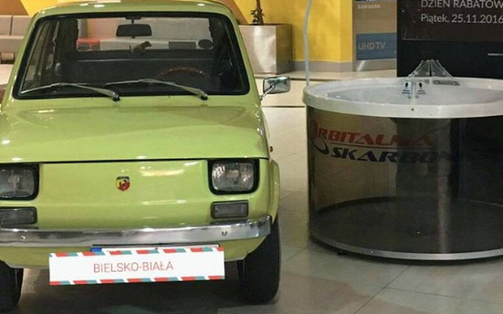 Zielony samochód w nowoczesnym otoczeniu.