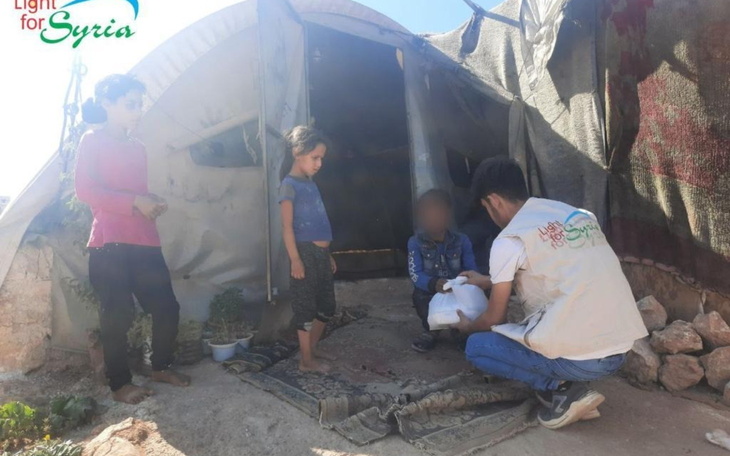 Dzieci w obozie, rozmawiające z wolontariuszem.