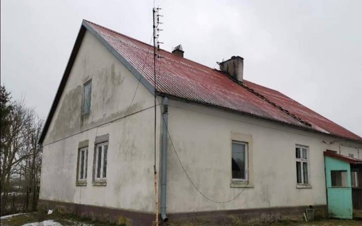 Stary dom z uszkodzonym dachem i anteną na kominie.