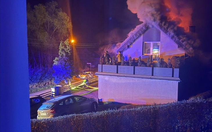 Pożar w budynku, strażacy pracujący w nocy.