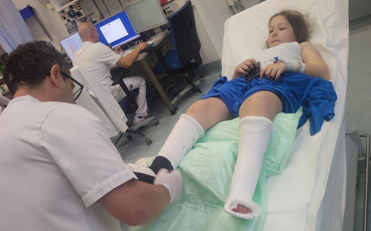 Dziewczynka w szpitalu z unieruchomionymi nogami.