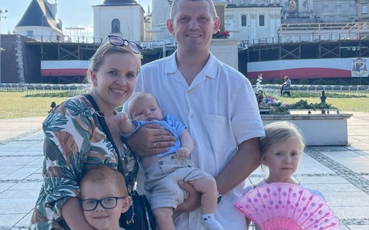 Rodzina pozująca na tle zabytkowego budynku.