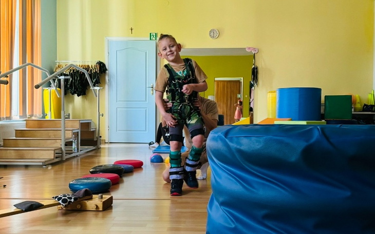 Dziecko bawi się w sali, pokonując przeszkody na torze.