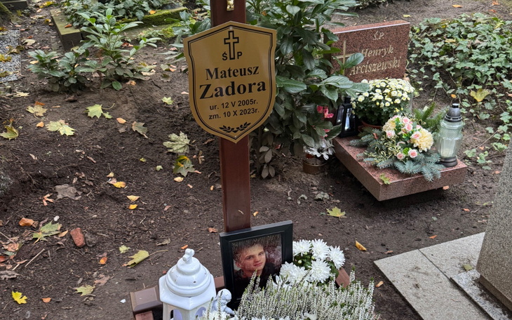 Nagrobek Mateusza Zadora z kwiatami i zniczami.