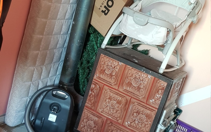 Zagracona przestrzeń z różnymi przedmiotami i meblami.