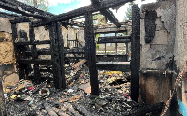 Zniszczony budynek po pożarze, z czarnymi ścianami.