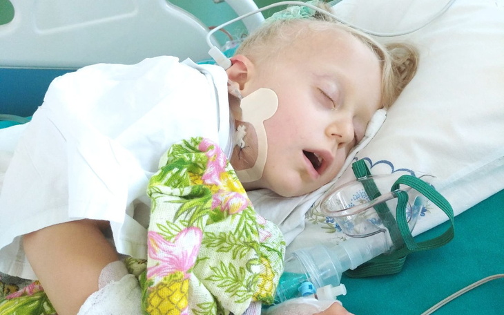 Mała dziewczynka śpiąca w szpitalnym łóżku.