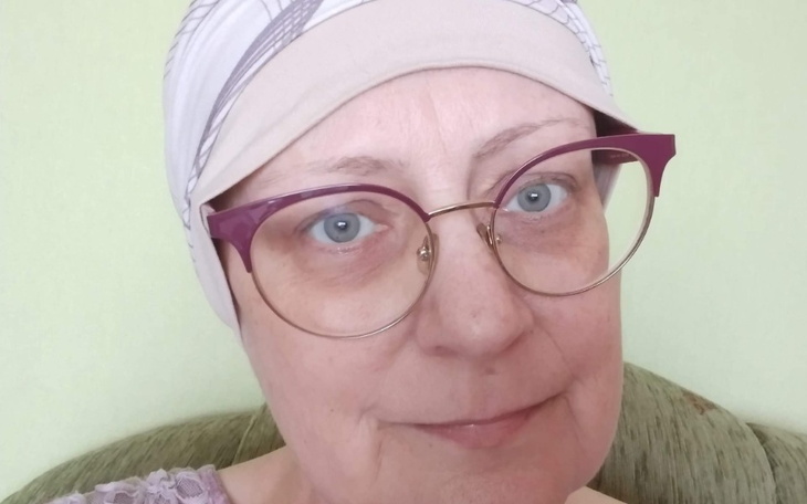 Kobieta w chustce, uśmiechająca się do kamery.