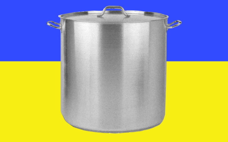 Duży garnek na tle ukraińskiej flagi.