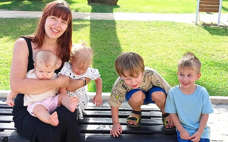 Kobieta z dziećmi na ławce w parku.