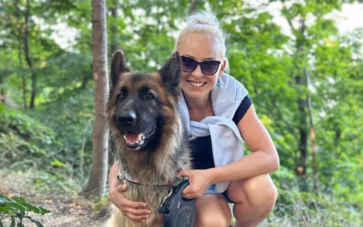 Kobieta z psem na spacerze w lesie.