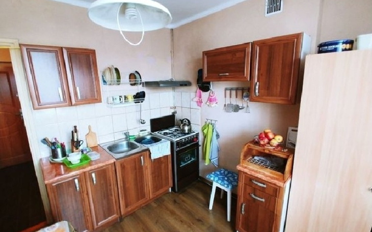 Kuchnia z drewnianymi meblami i sprzętem AGD.