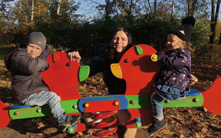 Dzieci bawiące się na huśtawce w parku.