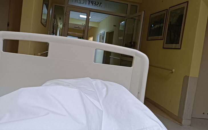 Pusty szpitalny łóżko z białą pościelą.