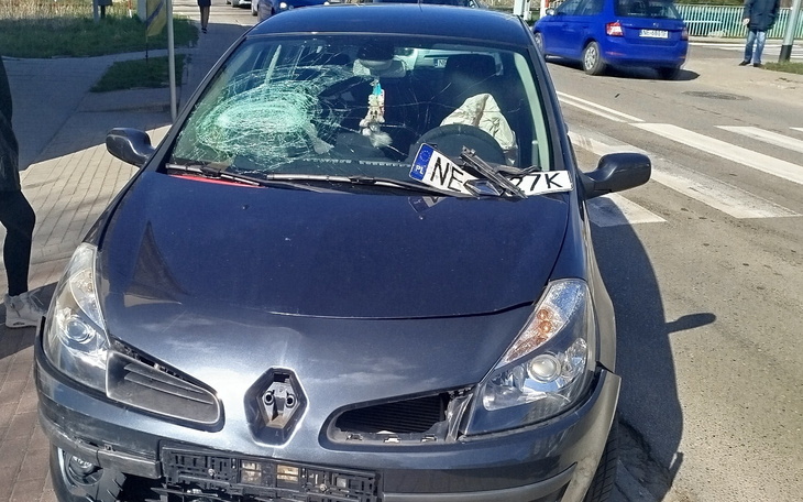 Uszkodzony samochód z rozbitą szybą na ulicy.
