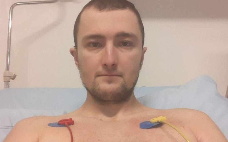 Mężczyzna w szpitalu, z elektrodami na klatce piersiowej.