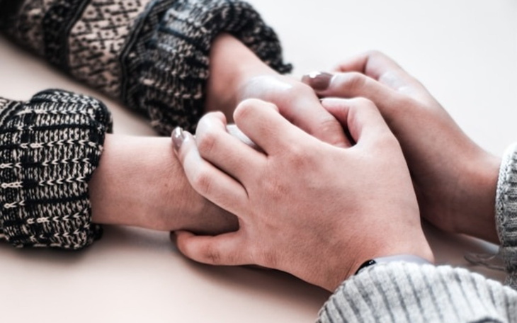 Dwie ręce trzymające się nawzajem w geście wsparcia.