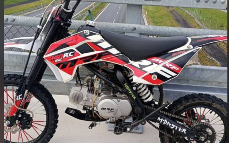 Motocykl w czerwono-czarnym kolorze na moście.