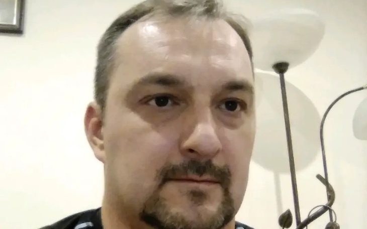 Mężczyzna w domowym otoczeniu, z lampą w tle.