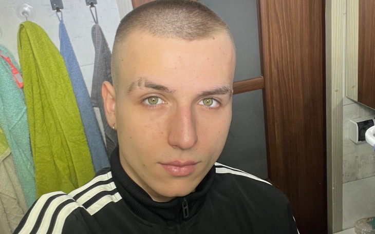 Młody mężczyzna z krótkimi włosami, patrzący w lustro.