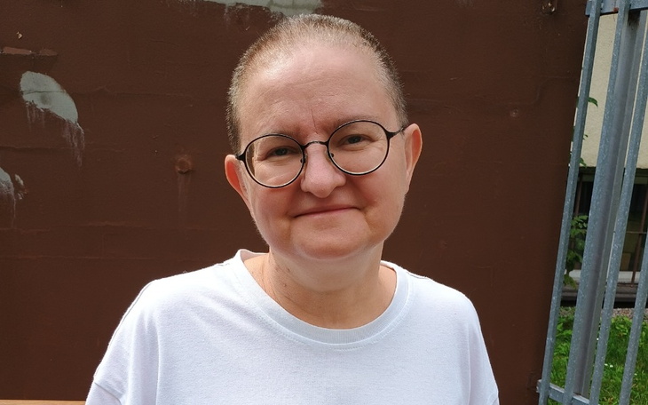 Kobieta w okularach, uśmiechająca się do kamery.