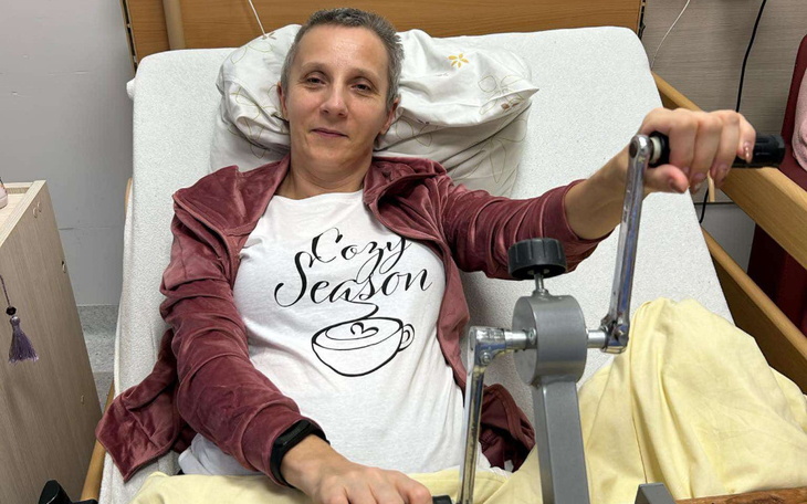 Kobieta w szpitalu, ćwicząca na urządzeniu rehabilitacyjnym.