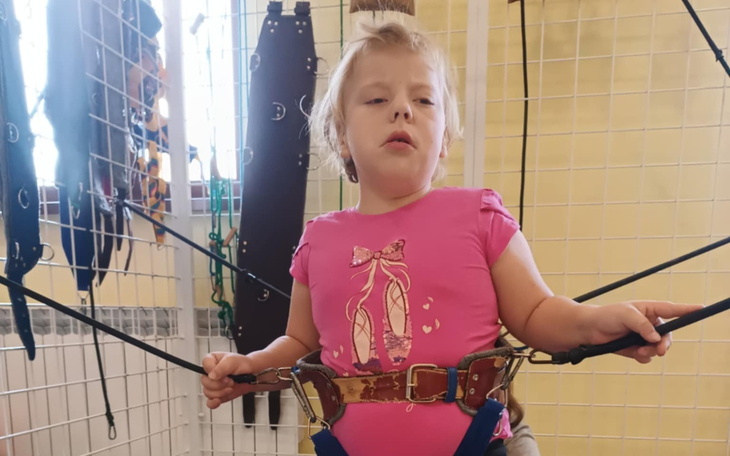 Dziecko w różowej koszulce na urządzeniu do skakania.