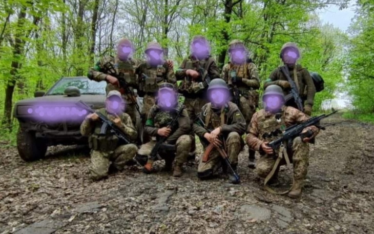 Grupa żołnierzy w lesie, z bronią i pojazdem.