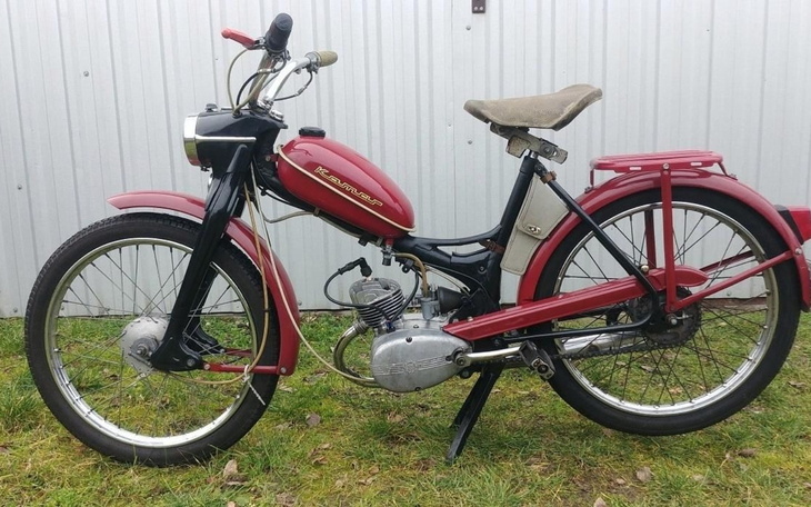 Czerwony motocykl z lat 70-tych na zielonej trawie.