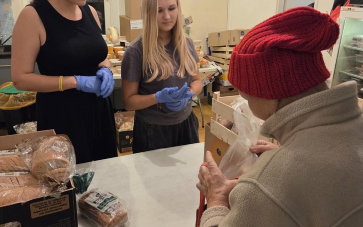 Wolontariusze pomagają osobom starszym w sklepie spożywczym.