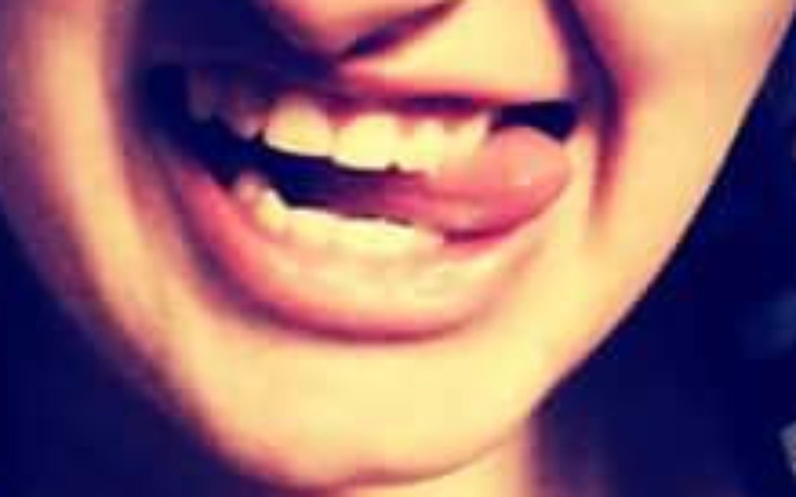 Zbliżenie na uśmiechniętą twarz z wystającym językiem.