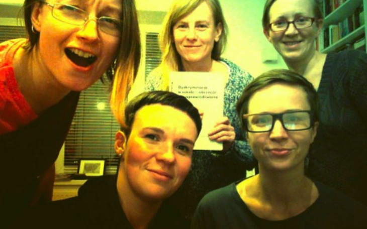 Grupa kobiet pozująca do zdjęcia w biurze.