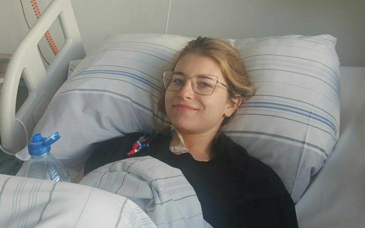 Pacjent w łóżku szpitalnym, uśmiechnięty, z przyjaznym wyrazem twarzy.