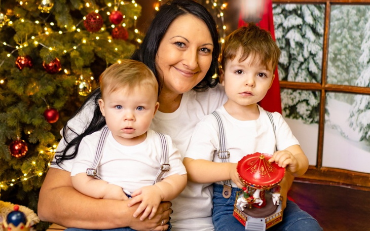 Mama z dwójką dzieci w świątecznym otoczeniu.