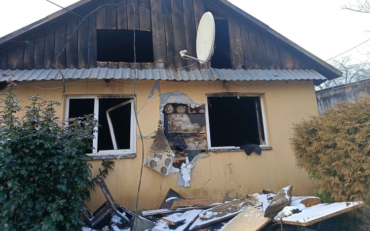 Zniszczony dom z uszkodzonymi oknami i dachem.