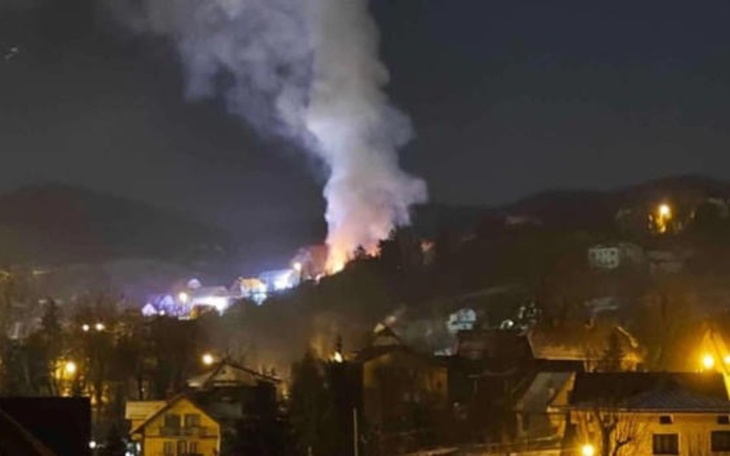 Widok na dym unoszący się nad miastem w nocy.