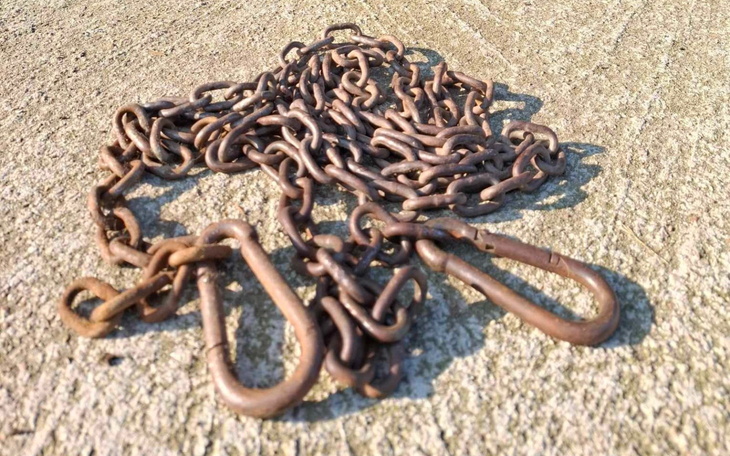 Zardzewiała łańcuch na betonie, symbolizująca trudne czasy.