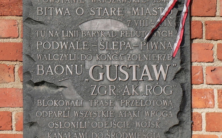 Pomnik upamiętniający bitwę, z wstążką w barwach narodowych.