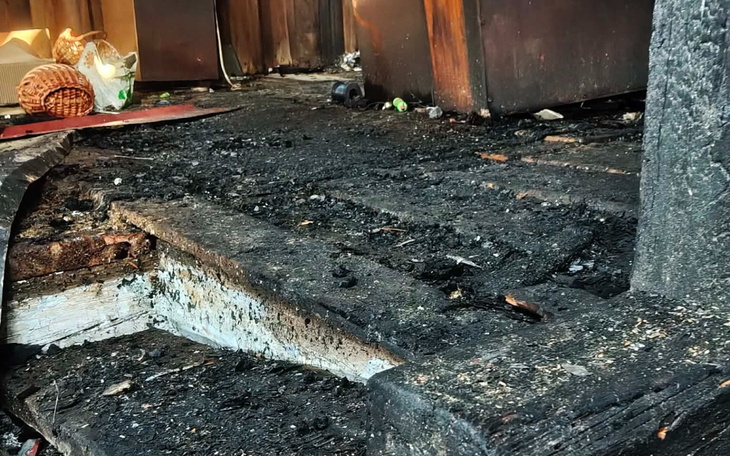 Zniszczona podłoga, pokryta sadzą i brudem.