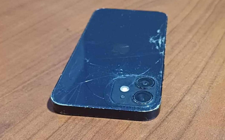 Zniszczony telefon leżący na drewnianym stole.