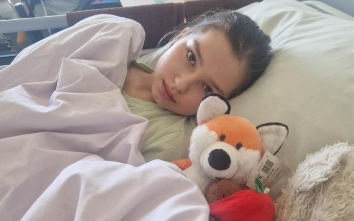 Dziewczynka w łóżku z pluszowym liskiem.