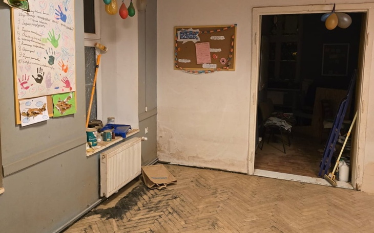 Pusty pokój z balonami i plakatami na ścianie, czekający na remont.