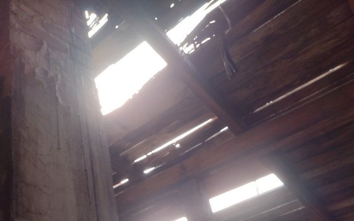 Zniszczony dach budynku, przez który wpada światło.