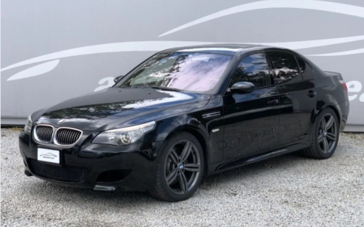 Czarny samochód marki BMW na tle szarego tła.